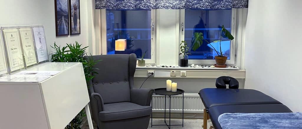 Interiören av Malin Anderssons holistiska hälsocenter på Hagåkersgatan 6A i Mölndal, med en bekväm fåtölj, massagebänk och lugnande inredning.